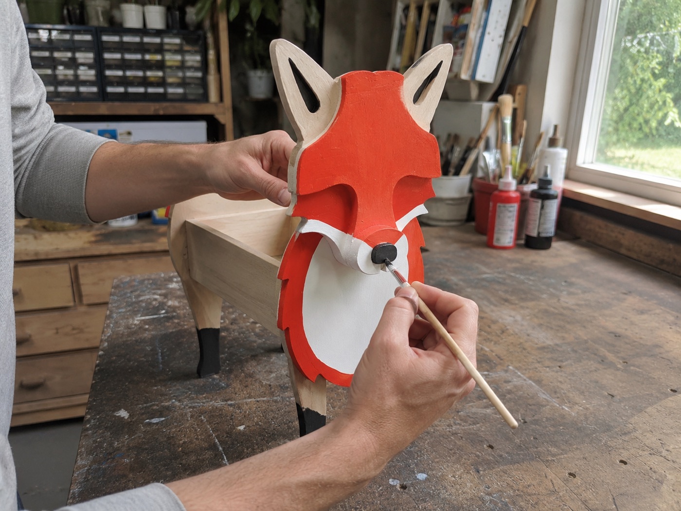 Kevin hand-painting detail onto a fox planter in the workshop