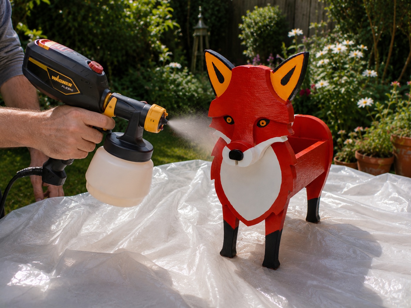 Spray-sealing a finished fox planter outside before it ships